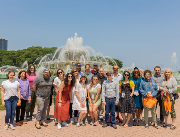 A large group of Spertus students standing in front of Chicago's Buckingham Fountain on a sunny summer day