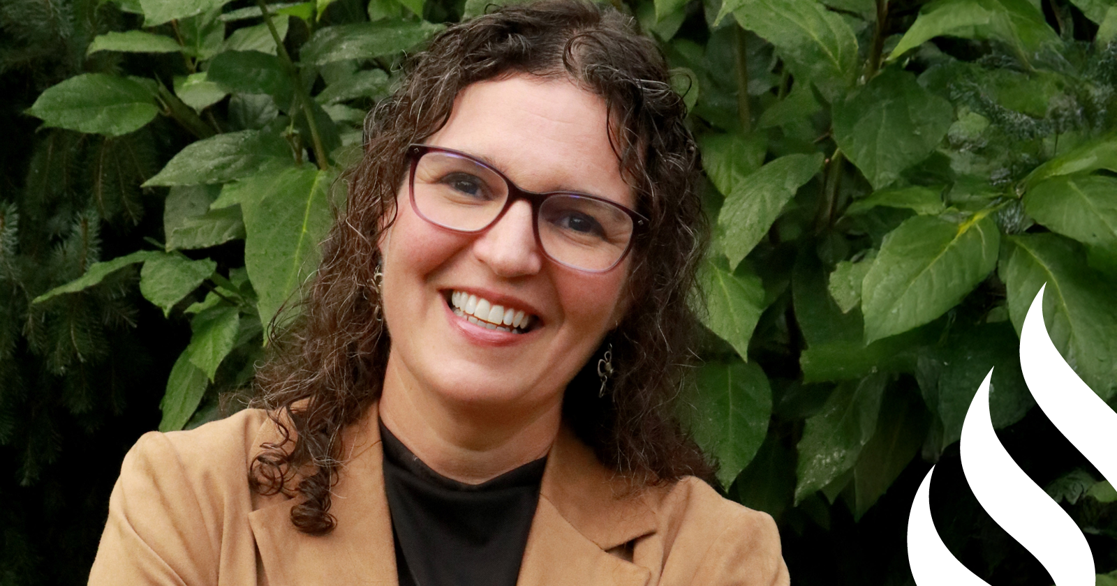 Rabbi Dr. Tali Zelkowicz stands in front of a leafy background